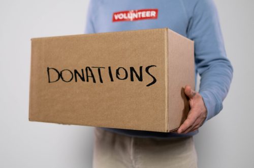 a volunteer carrying a box of donations